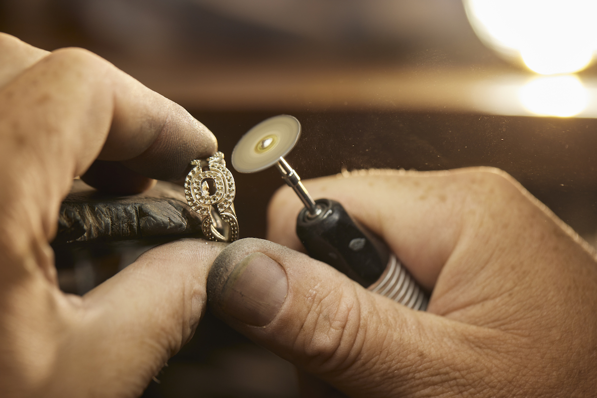 close-up of a jewellery using a tool to modify an engagement ring